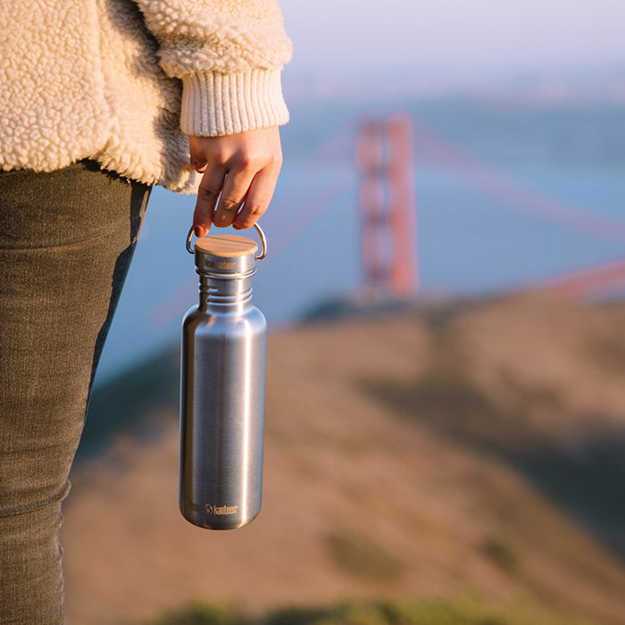 27oz-reflect-with-bamboo-cap-k0 K27SSLRF-BS-BAMBOO_reflect_bottle_bridge_lifestyle.jpg